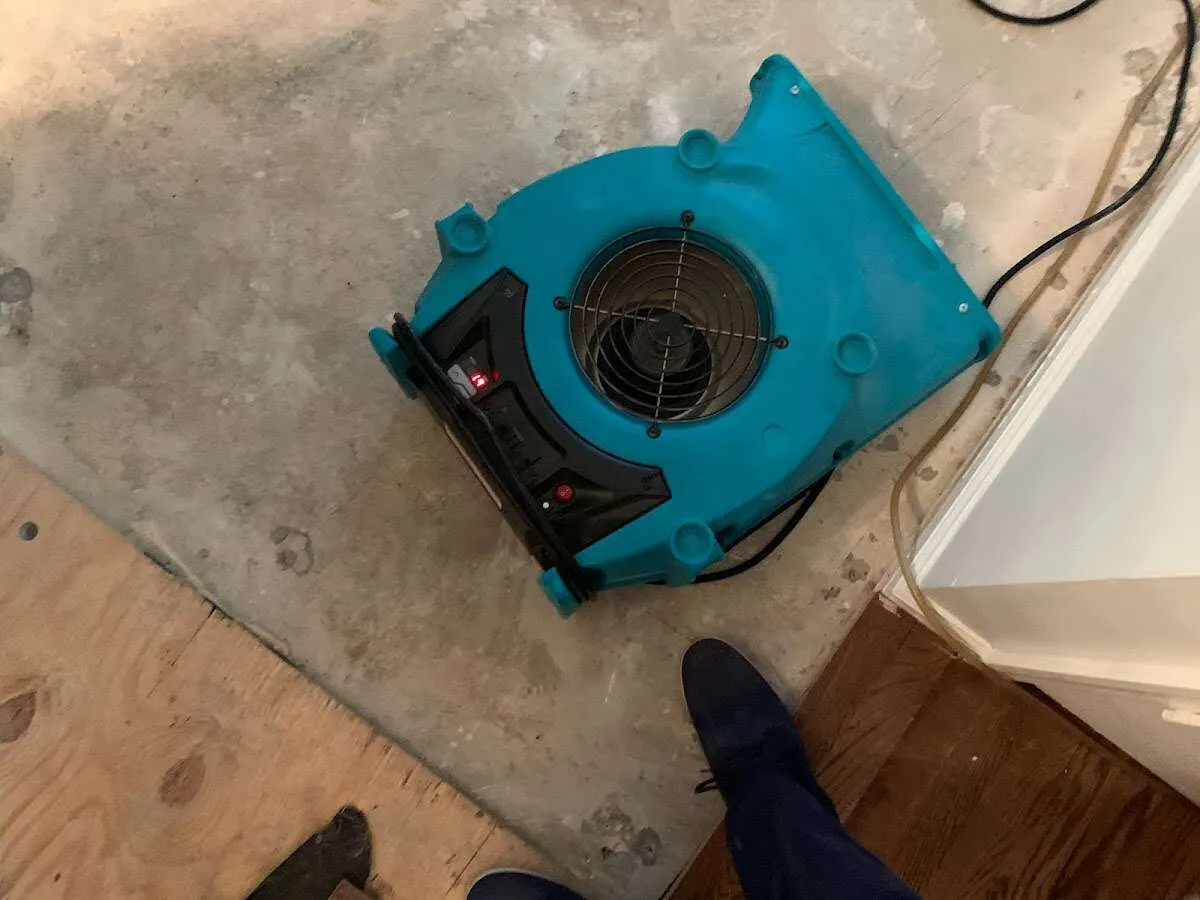 Air mover drying subfloor during Commercial Water Damage Restoration in Tahlequah